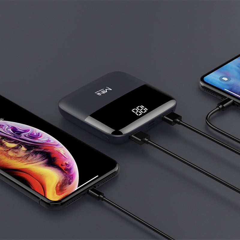 Two smartphones connected to a power bank on a dark surface