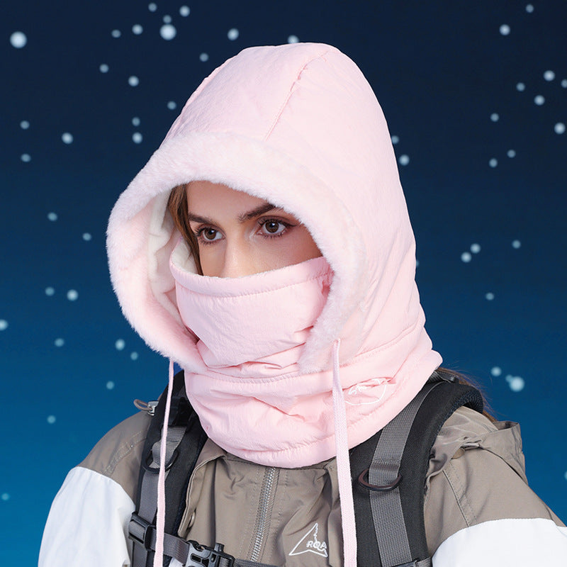 Person wearing a pink hood and scarf against a snowy background