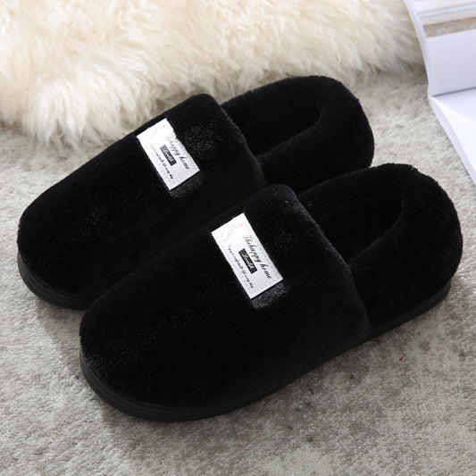 Black slippers with labels on a textured surface