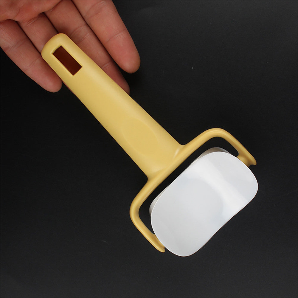 Yellow peeler with a white blade held by a hand on a black background