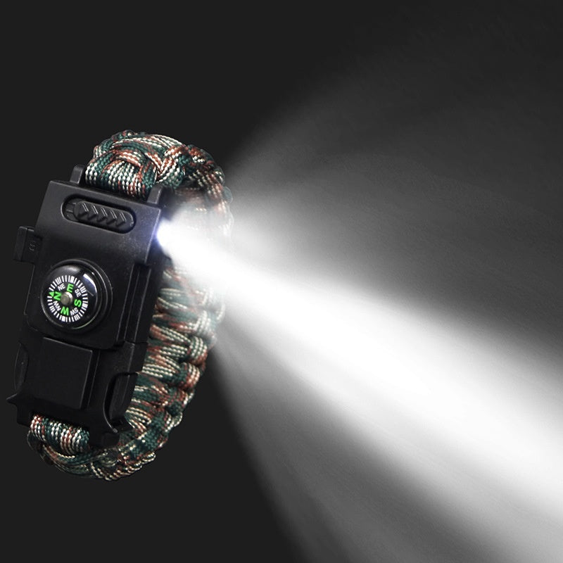 Paracord bracelet with flashlight and compass on a dark background