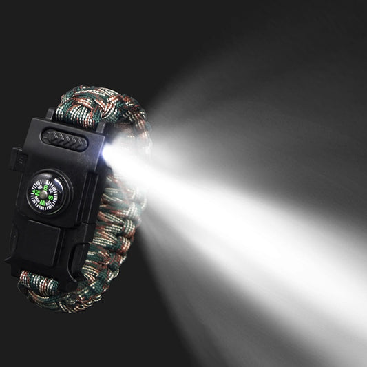 Paracord bracelet with flashlight and compass on a dark background