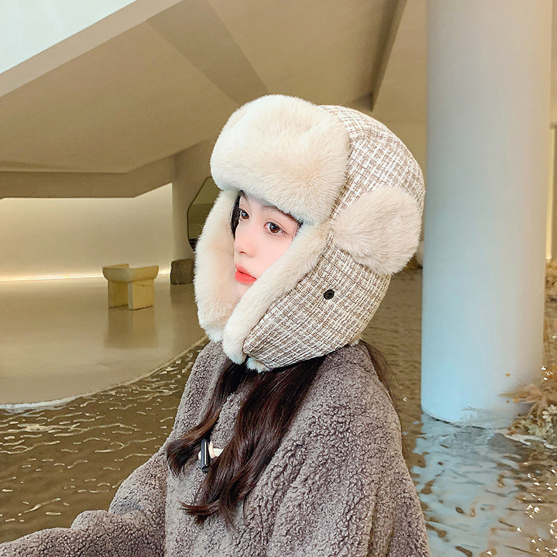 Person wearing a fur-lined hat and coat in an indoor setting