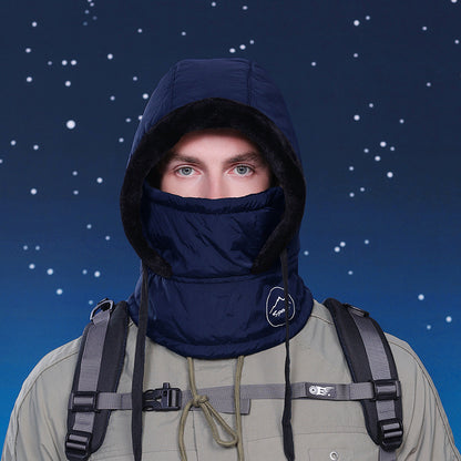 Person wearing a dark blue hood and balaclava with a backpack against a starry night sky.