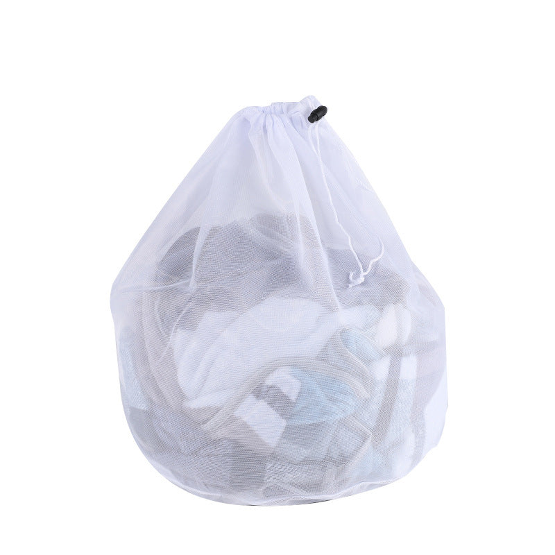 Three different sized clear laundry bags filled with laundry items, placed in front of a washing machine.