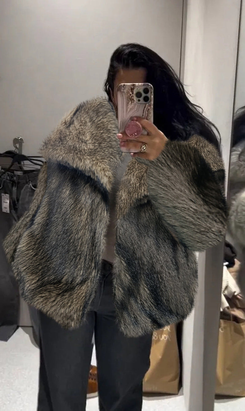 Person wearing a fur coat taking a mirror selfie.