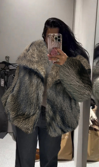 Person wearing a fur coat taking a mirror selfie.