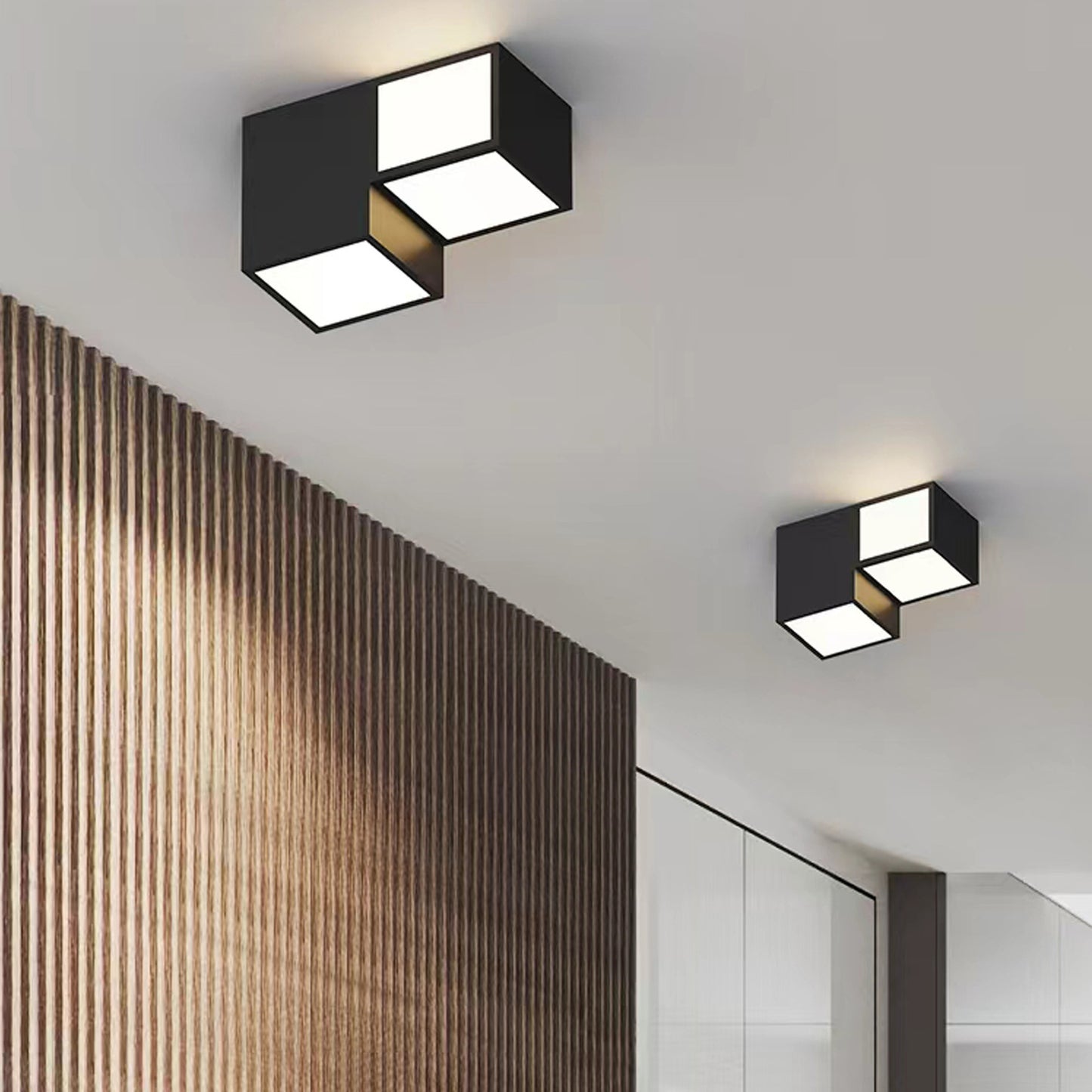 Modern ceiling lights in a hallway with wooden wall paneling.