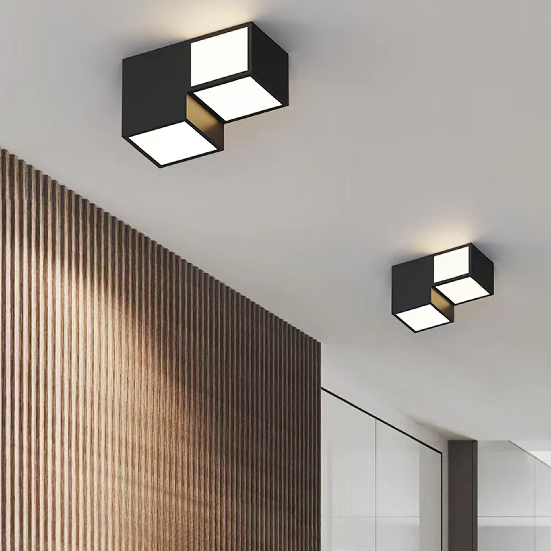 Modern ceiling lights in a hallway with wooden wall paneling.