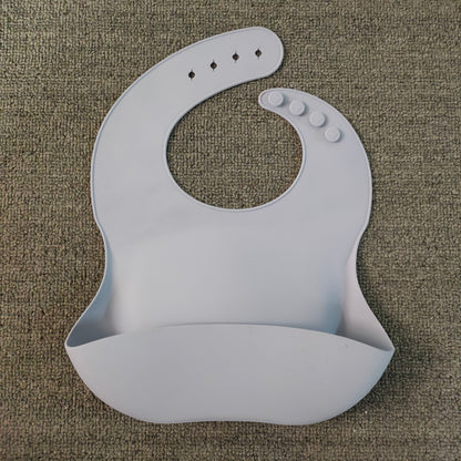 Gray silicone bib on a textured brown surface