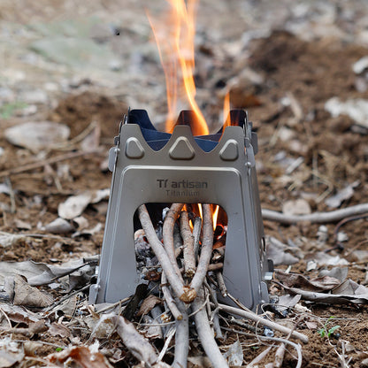 Portable stove with fire burning on a natural ground background