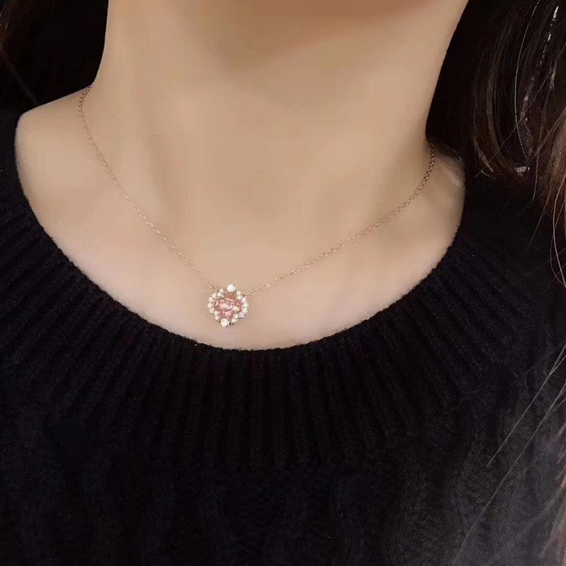Necklace with a floral pendant worn by a person against a black background