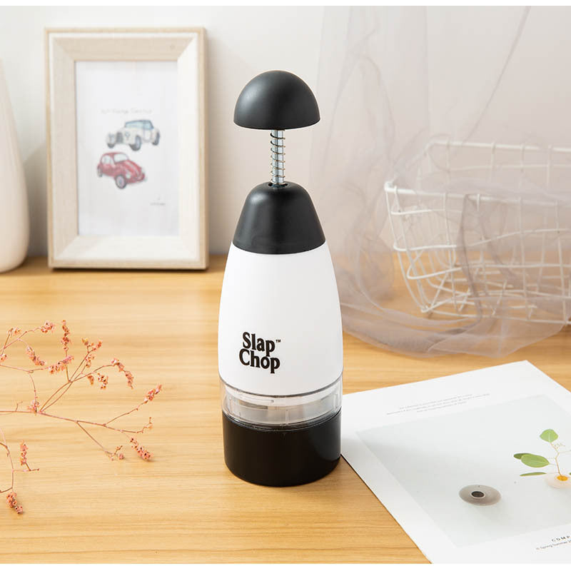 Slap Chop kitchen tool on a wooden surface with a light background