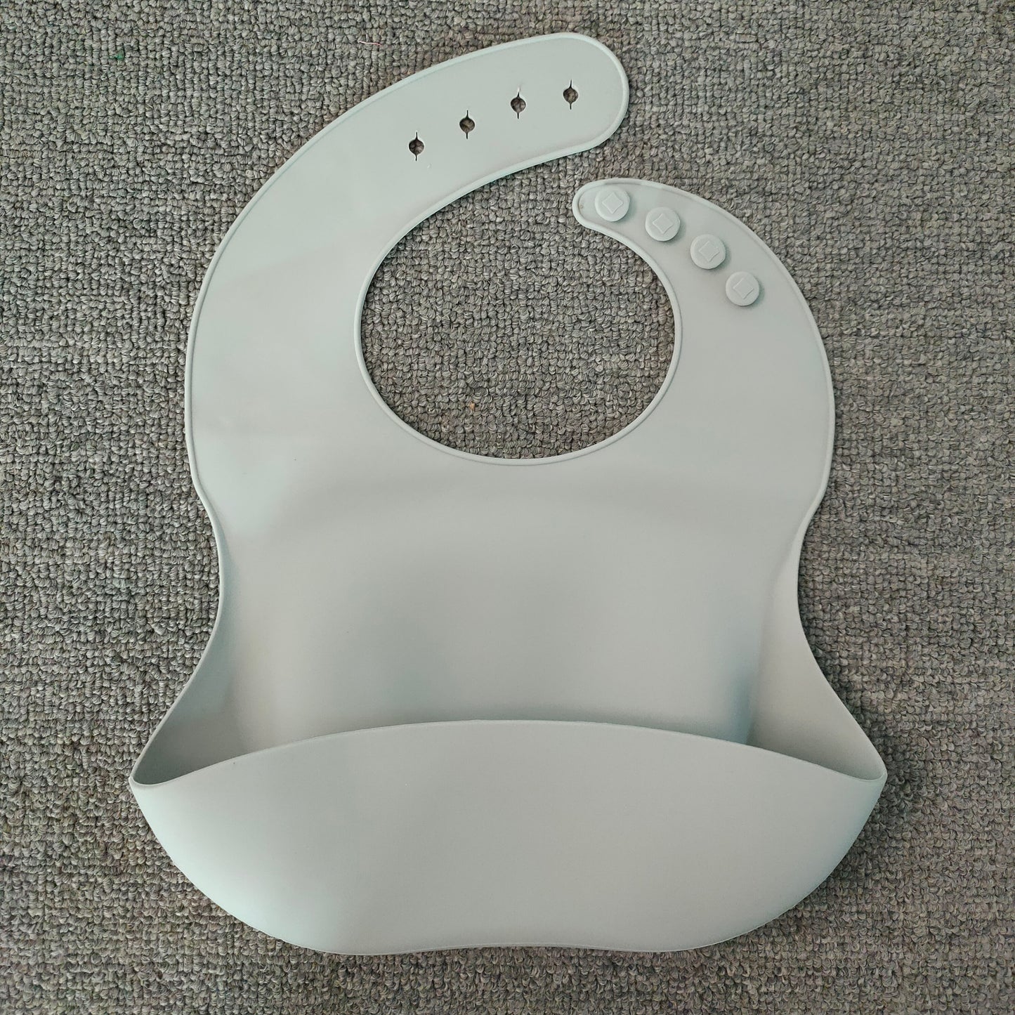 Gray silicone bib on a textured gray surface