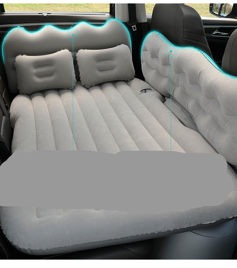 Inflatable car mattress with head guard and children's gear board in a vehicle.