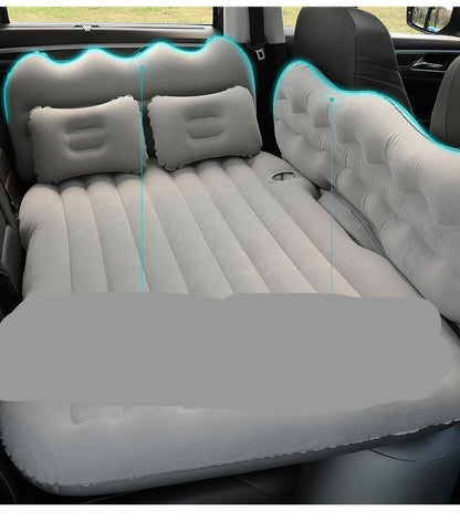 Inflatable car mattress with head guard and children's gear board in a vehicle.