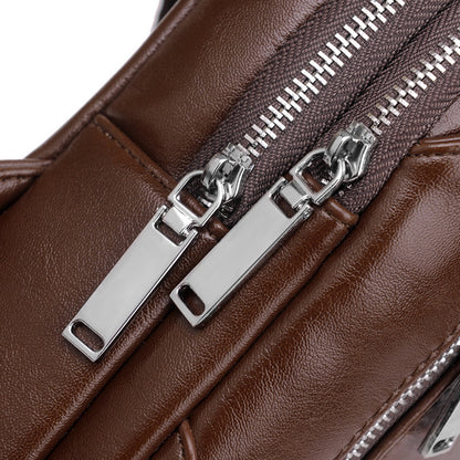 Close-up of a brown leather bag with silver zippers on a white background