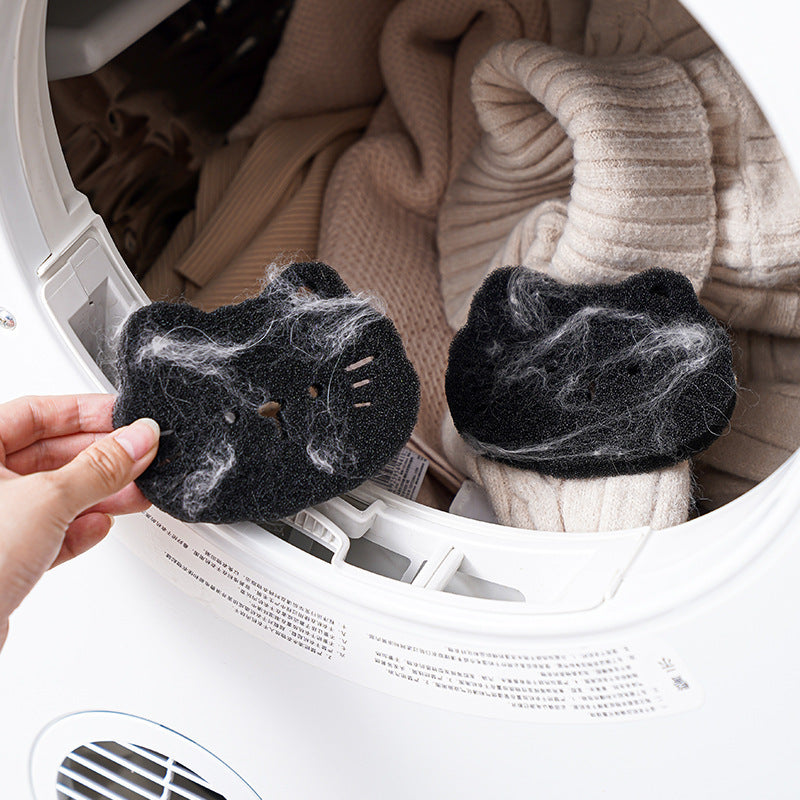 Person removing dirty dryer balls from a dryer with clothes in the background