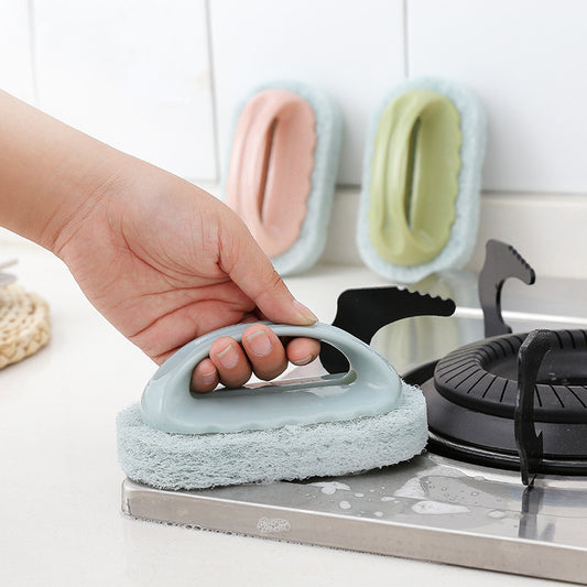 Hand holding a blue scrubber over a stove with other scrubbers in the background.