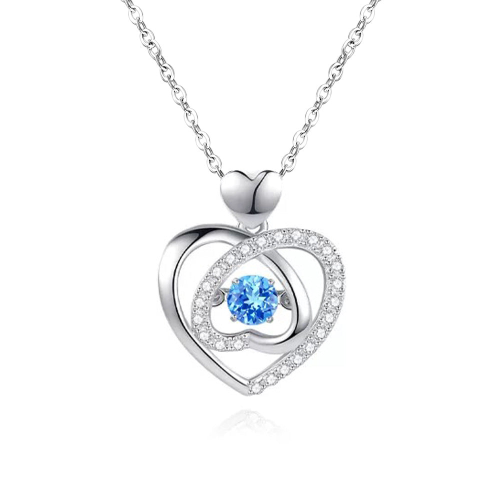 Silver heart-shaped necklace with a blue gemstone on a white background