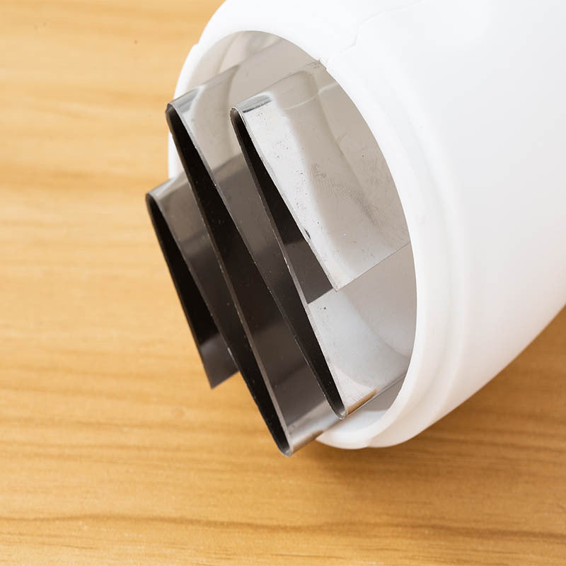 Close-up of a white and black plastic component on a wooden surface