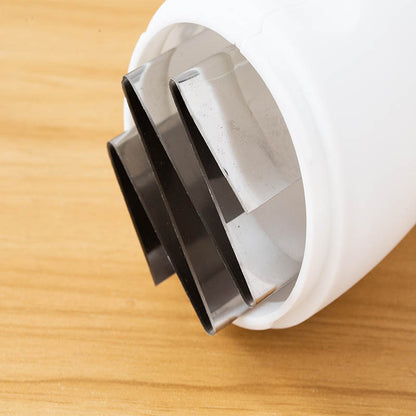 Close-up of a white and black plastic component on a wooden surface