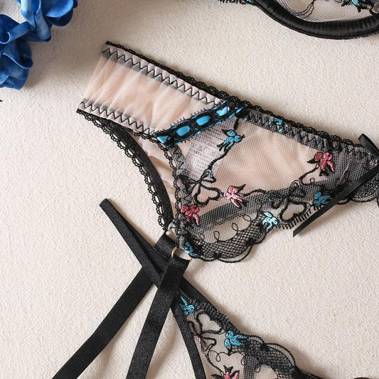 Black lace lingerie set with floral embroidery on a light background