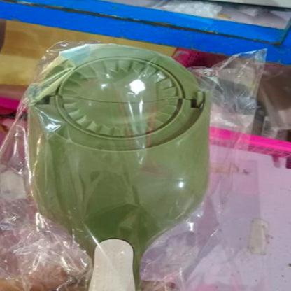 Green kitchen tool with a white handle on a plastic bag background