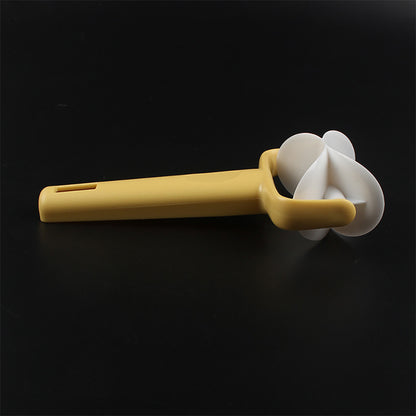 Yellow kitchen tool with a white handle on a black background