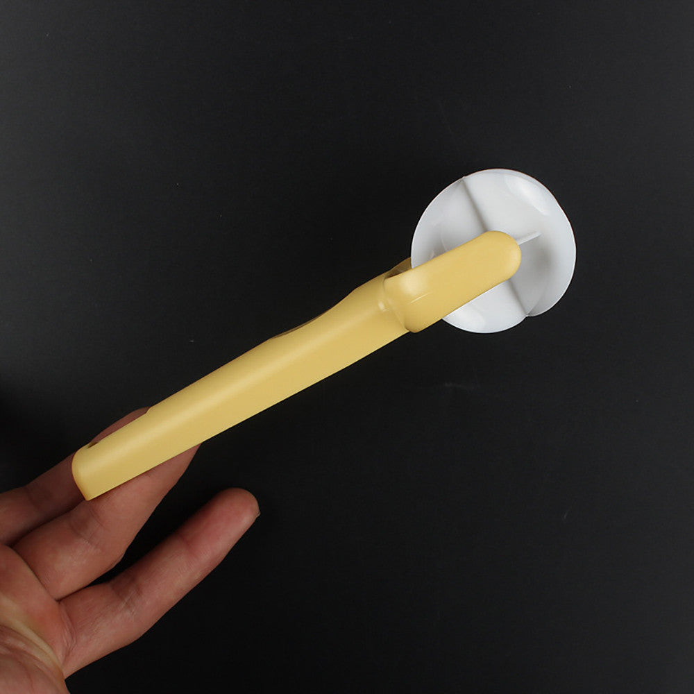 Hand holding a yellow kitchen tool with a white circular component against a black background