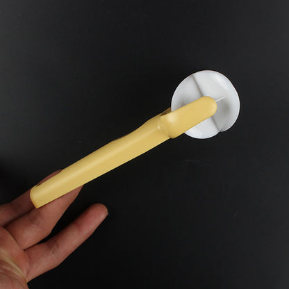 Hand holding a yellow kitchen tool with a white circular component against a black background