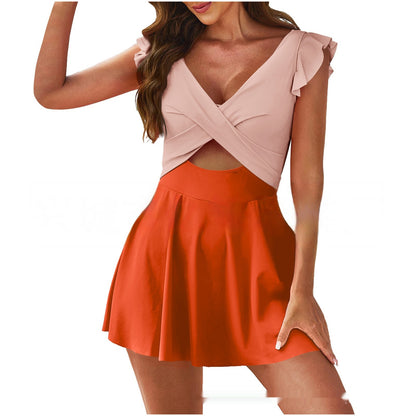 Woman wearing a two-tone dress with pink top and orange skirt on a white background