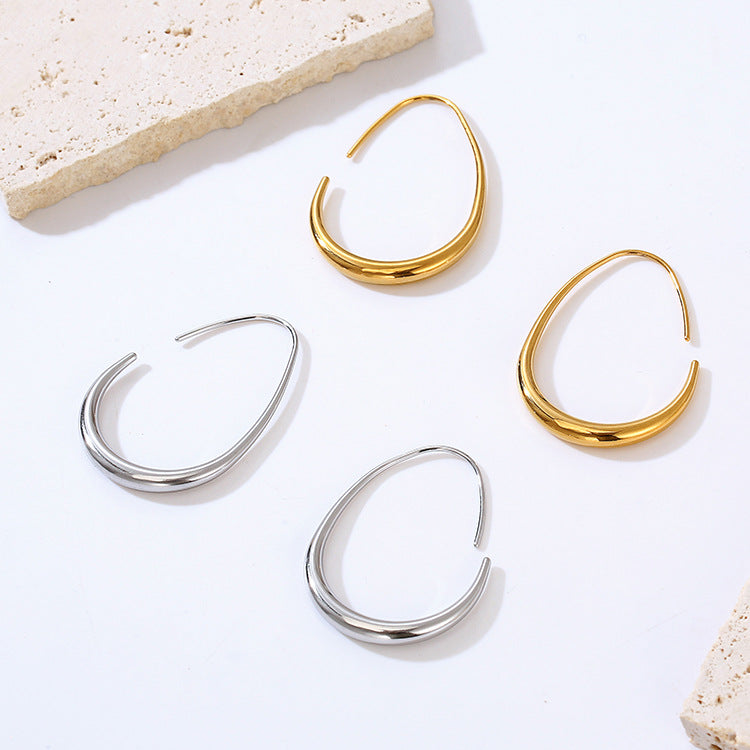 Gold and silver hoop earrings on a light background
