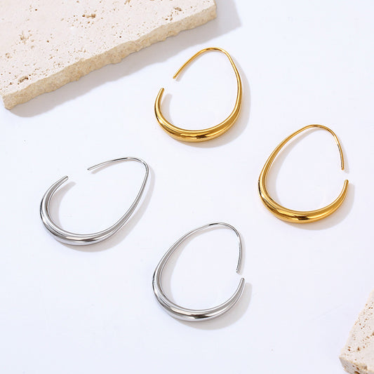 Gold and silver hoop earrings on a light background