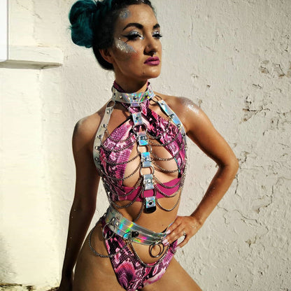 Woman in a colorful and revealing outfit against a white wall.