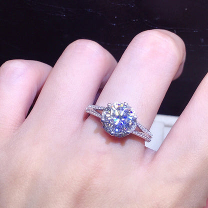 Silver ring with a large diamond on a hand against a dark background