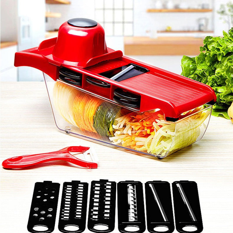 Red vegetable slicer with clear container filled with sliced vegetables on a kitchen counter.