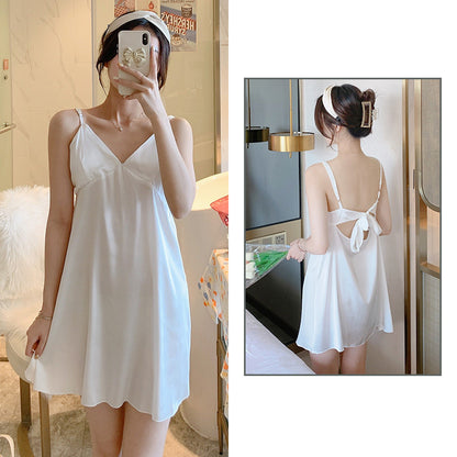 Woman wearing a white slip dress in a room setting.