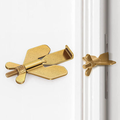 Gold door stopper attached to a white door