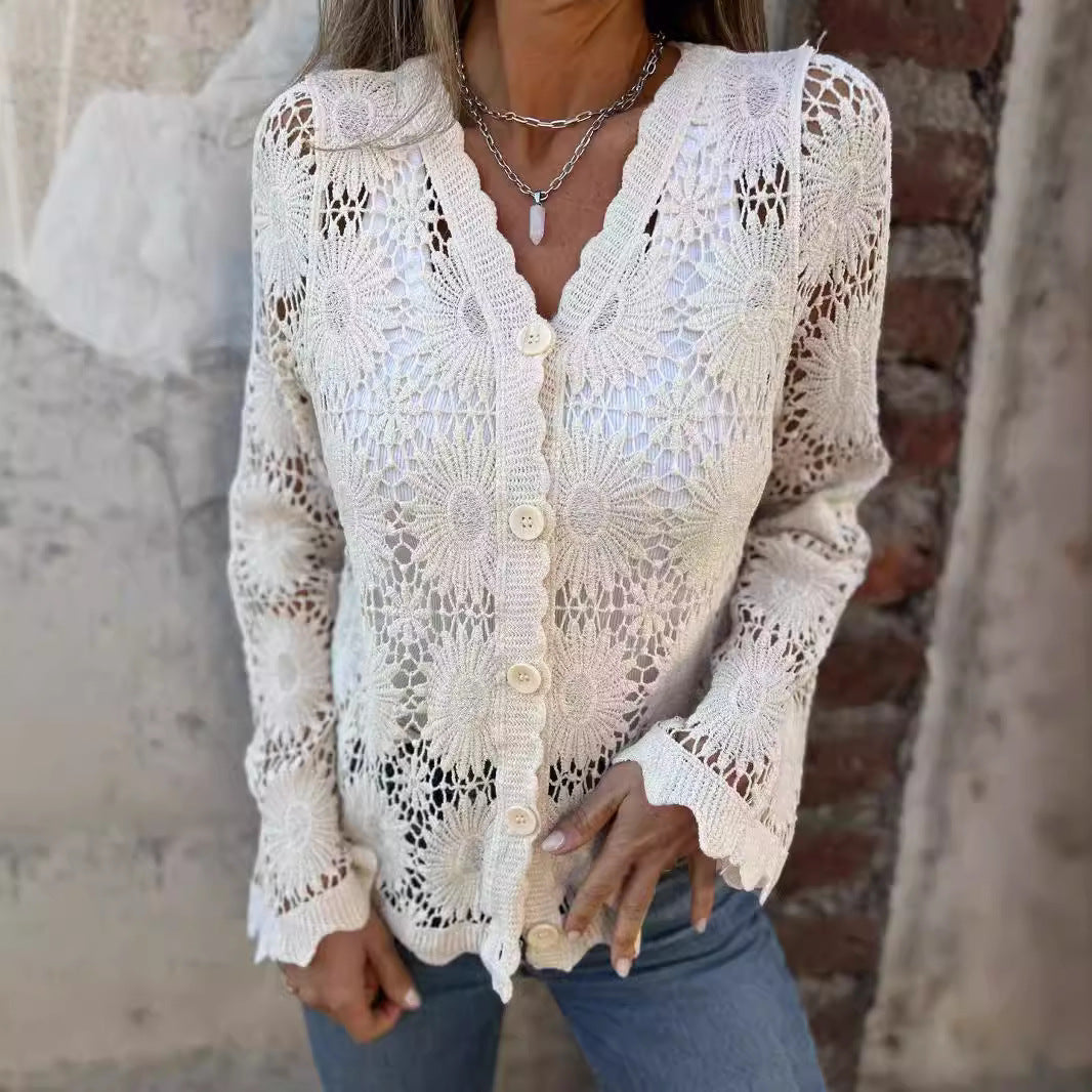 Woman wearing a white crochet cardigan against a textured wall.