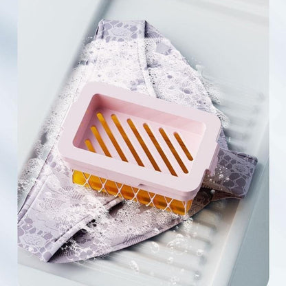 Pink and yellow soap dish on a white towel with text about easy foaming.