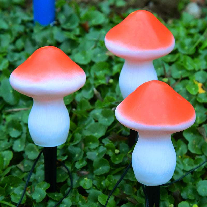 Three mushroom-shaped lights on green grass