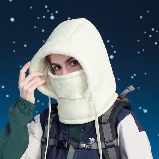 Person wearing a white hooded balaclava against a snowy night background