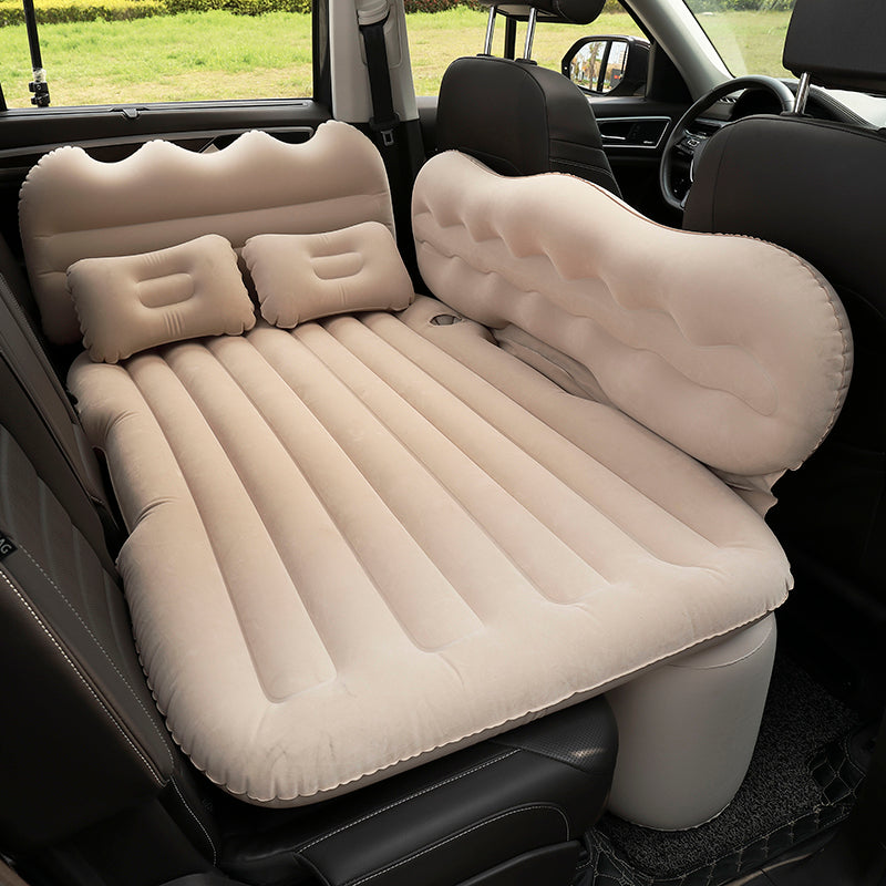 Inflatable car mattress set up in a vehicle with two pillows.