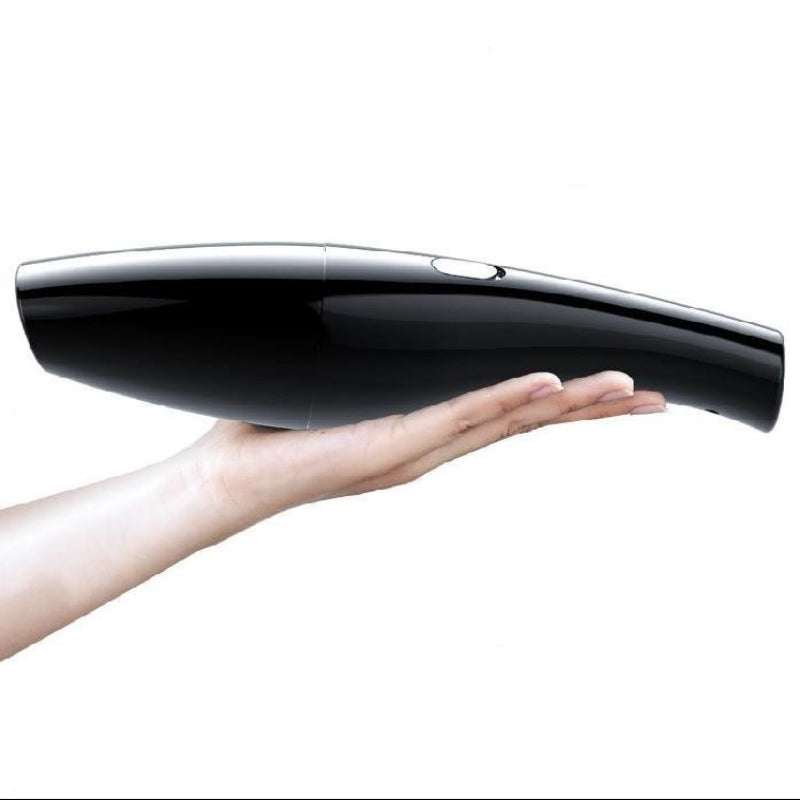 Black handheld vacuum cleaner held in a hand on a white background