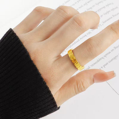 Hand wearing a yellow ring on a white background
