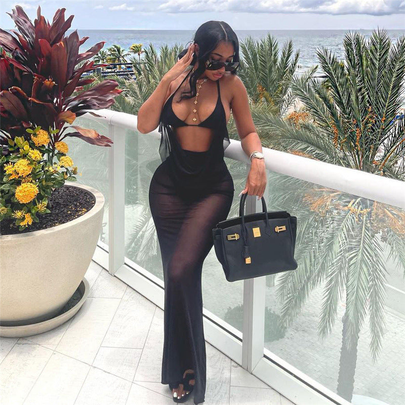 Woman in a black outfit holding a black handbag on a balcony with ocean view