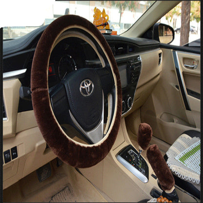 Car interior with a brown steering wheel cover and dashboard accessories.