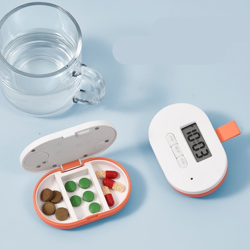 Mini pill box with digital timer next to a glass of water on a light blue background