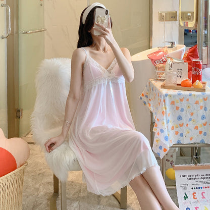A woman sitting on a bathroom counter wearing a black nightgown with a square neckline and lace details.